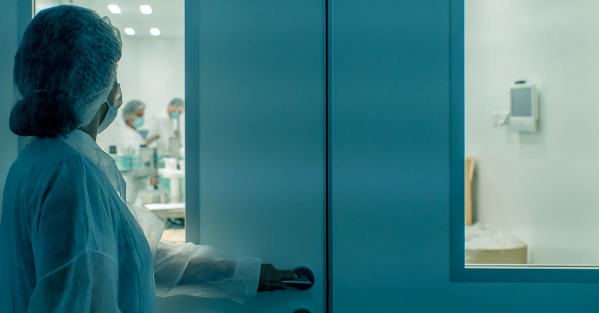 Close-up of a patient's hand holding a smartphone with a clinic appointment reminder notification on the screen.