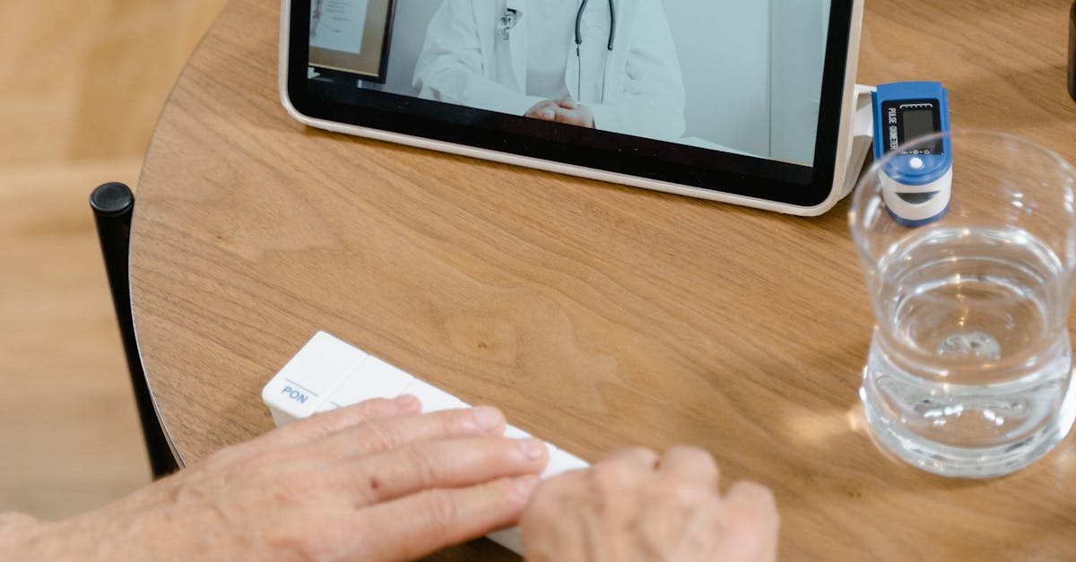 Doctor in a cardiology clinic pointing to a heart diagram on a screen while consulting with an elderly patient.
