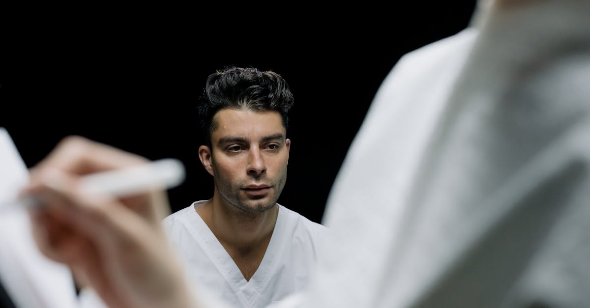 A professional doctor in a white coat conducting a secure telemedicine video consultation with a patient from their office desk.