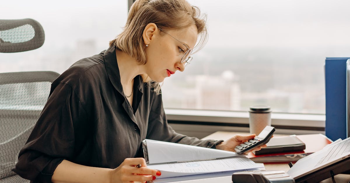 Clinic administrator reviewing digital invoices and financial reports on a computer screen with Tadawi interface.