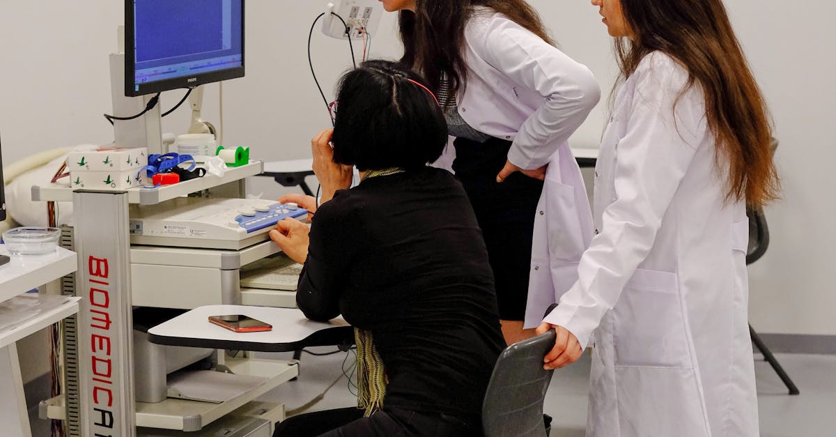 Doctor using a clinic management system on a desktop computer to view patient records.